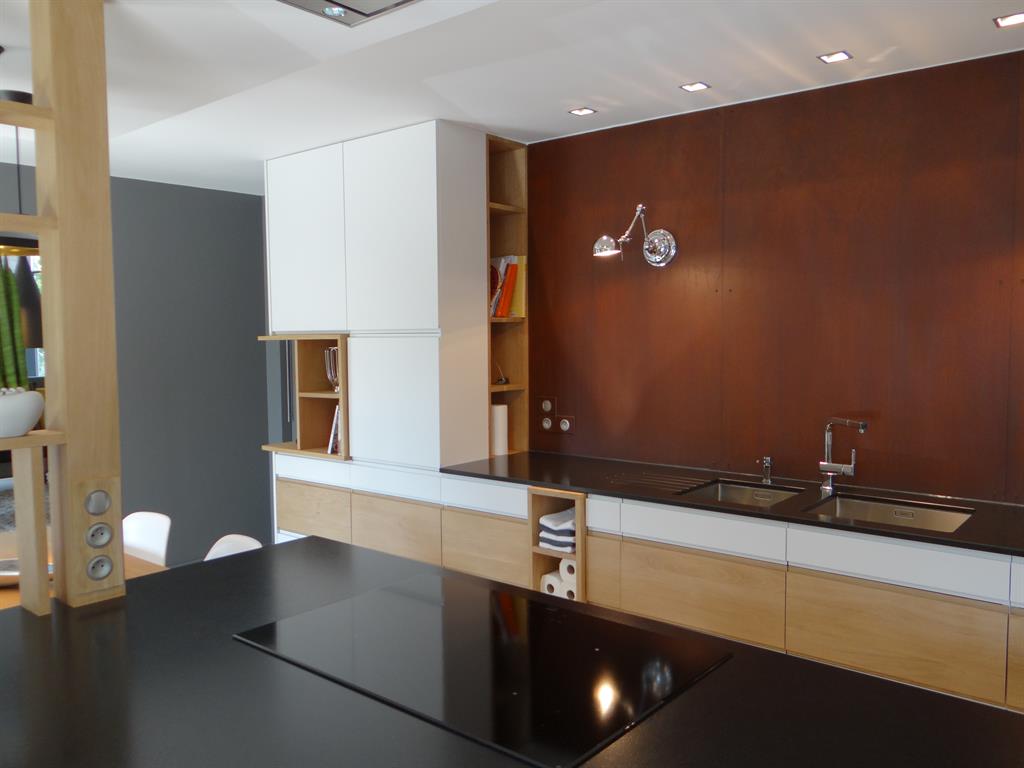 Cuisine contemporaine avec niches en bois et mur rouillé