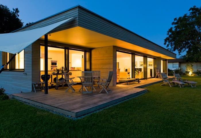 Villa en bardage bois avec toit plat et terrasse bois intégree